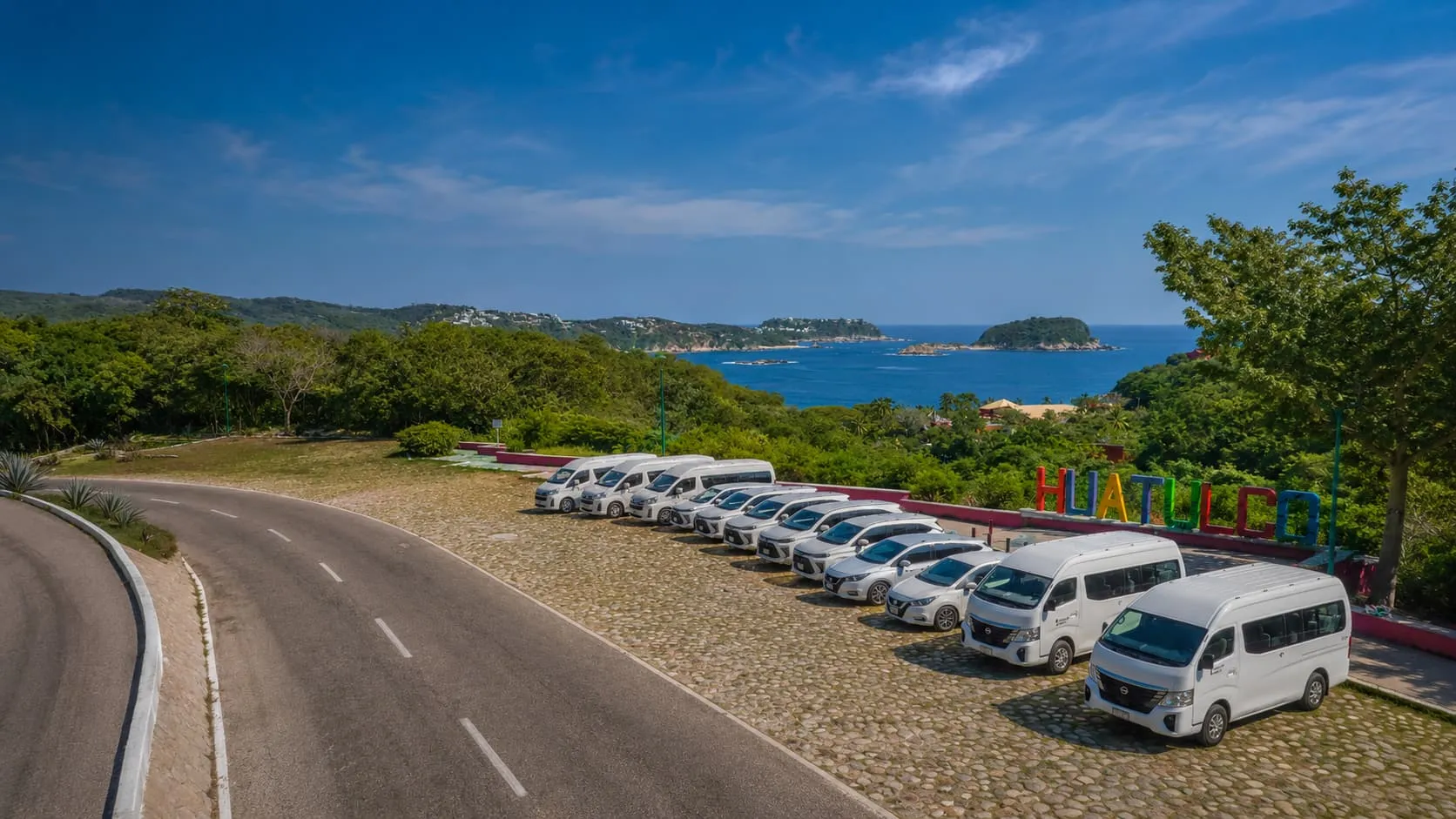 Official Transporte Terrestre fleet parked in front of Huatulco Airport